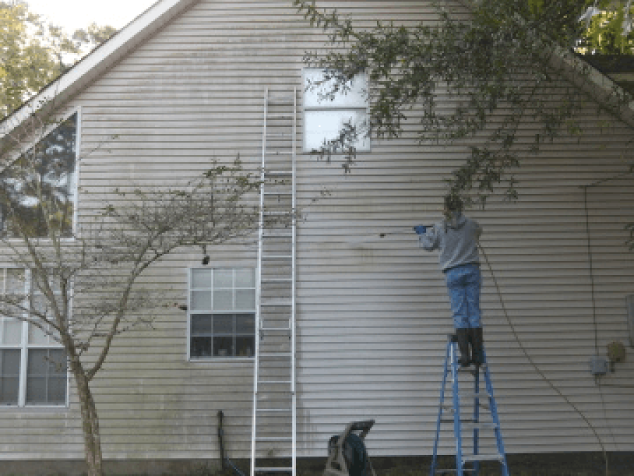Dewey pressure washing siding on a home